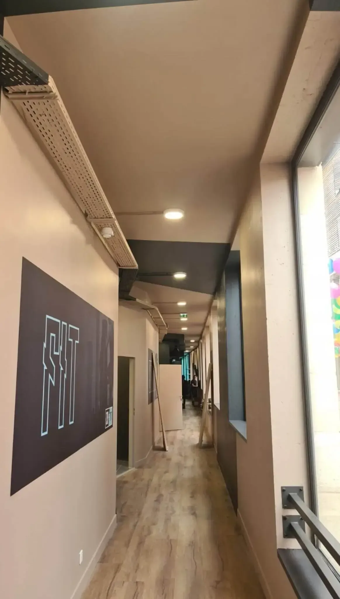 Spots intégrés au plafond dans le couloir d'une salle de sport.