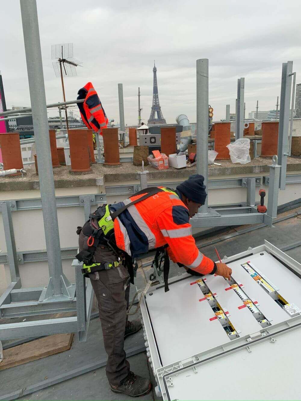 Un homme tire des câbles sur un toit.