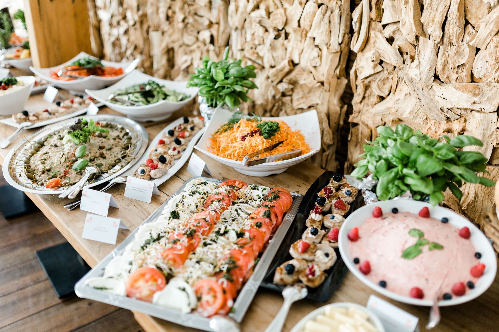 Buffettisch mit verschiedenen Gerichten: Lachs, Pasta, Salate und Beilagen, drinnen.