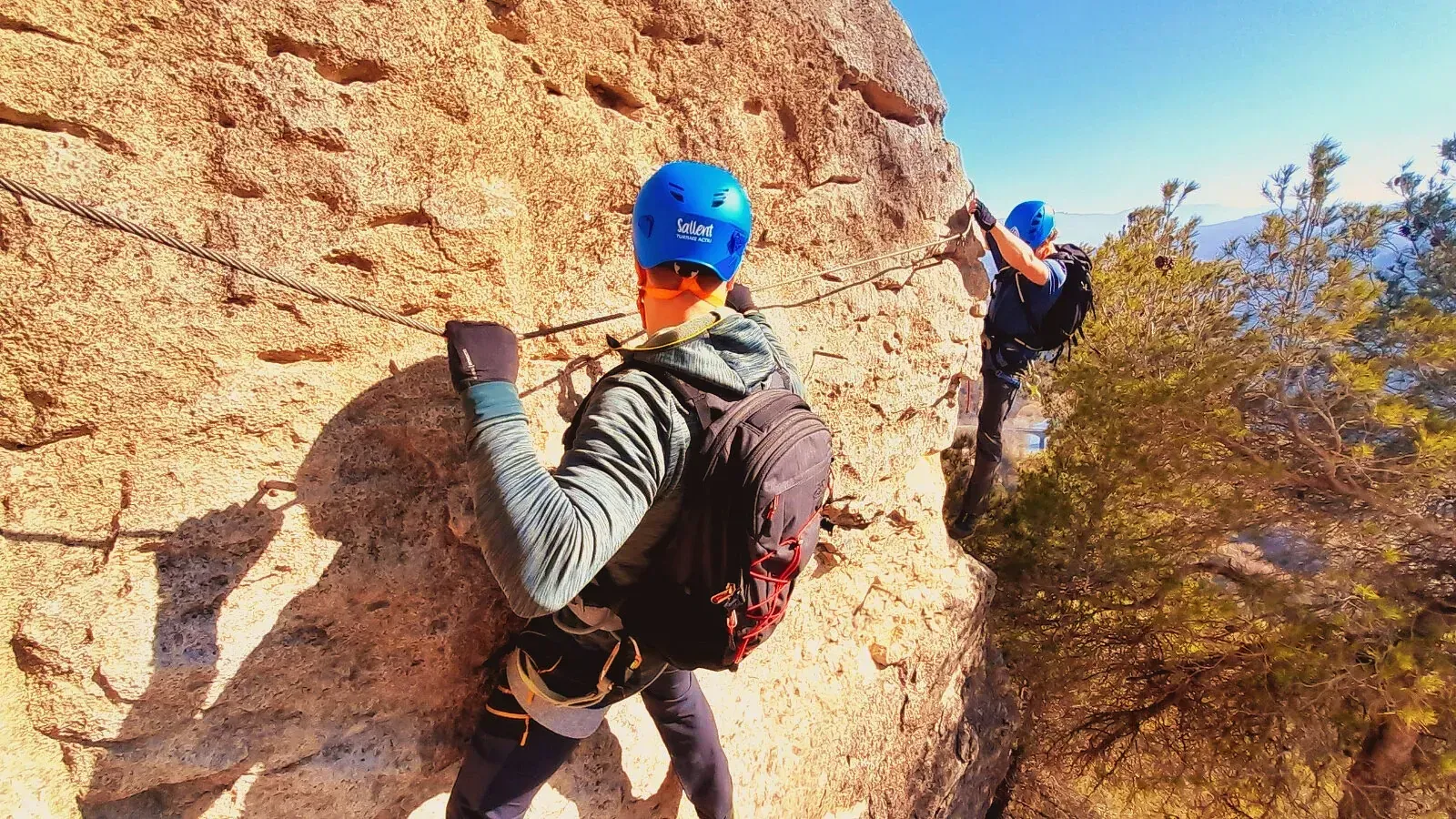 Un hombre y una mujer están escalando una pared de roca.