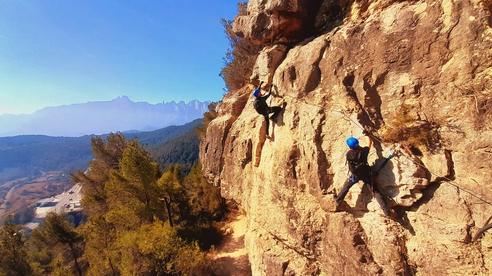 Una pareja está escalando una pared de roca.