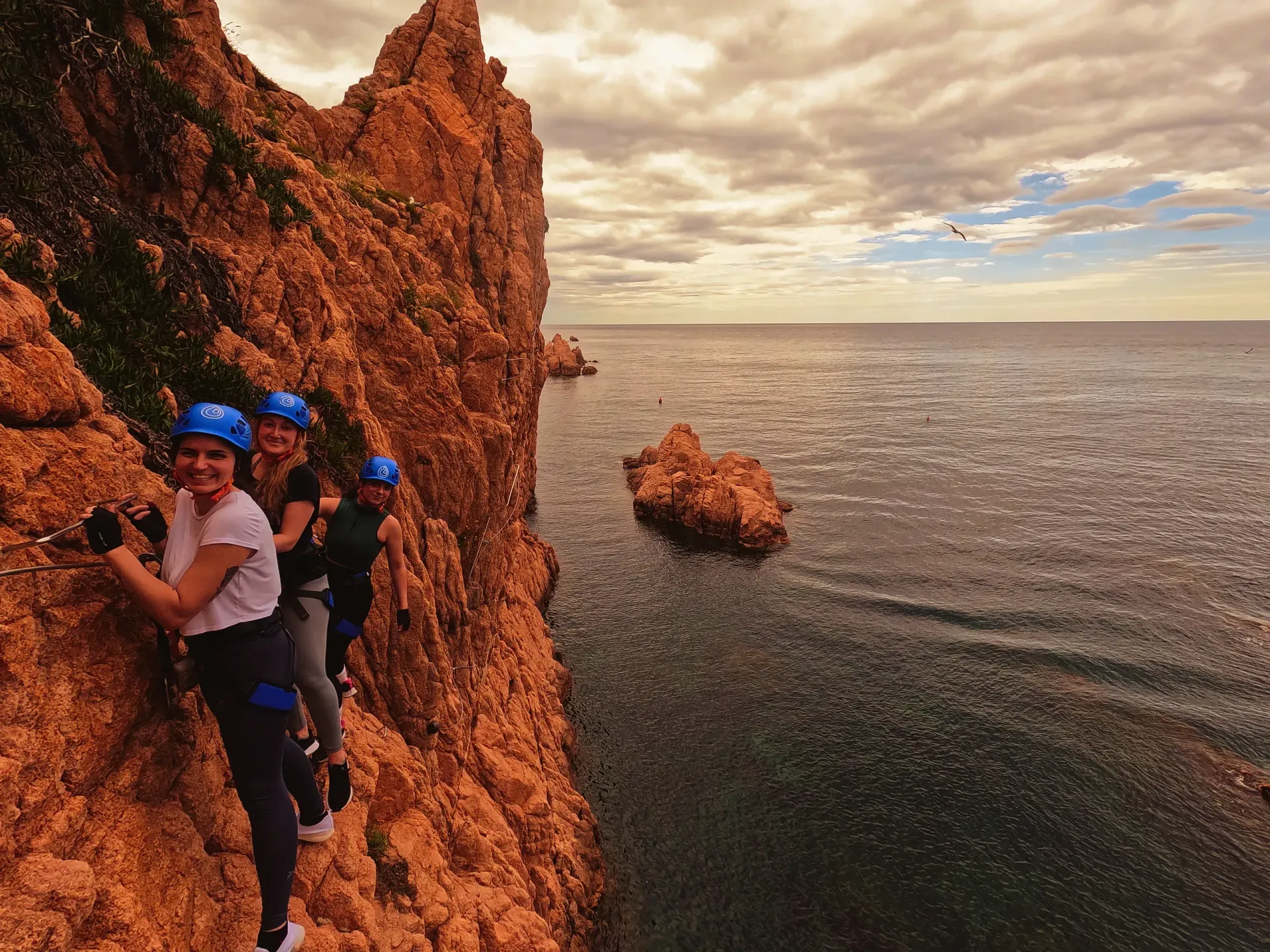 Un grupo de personas está escalando un acantilado con vistas al océano.