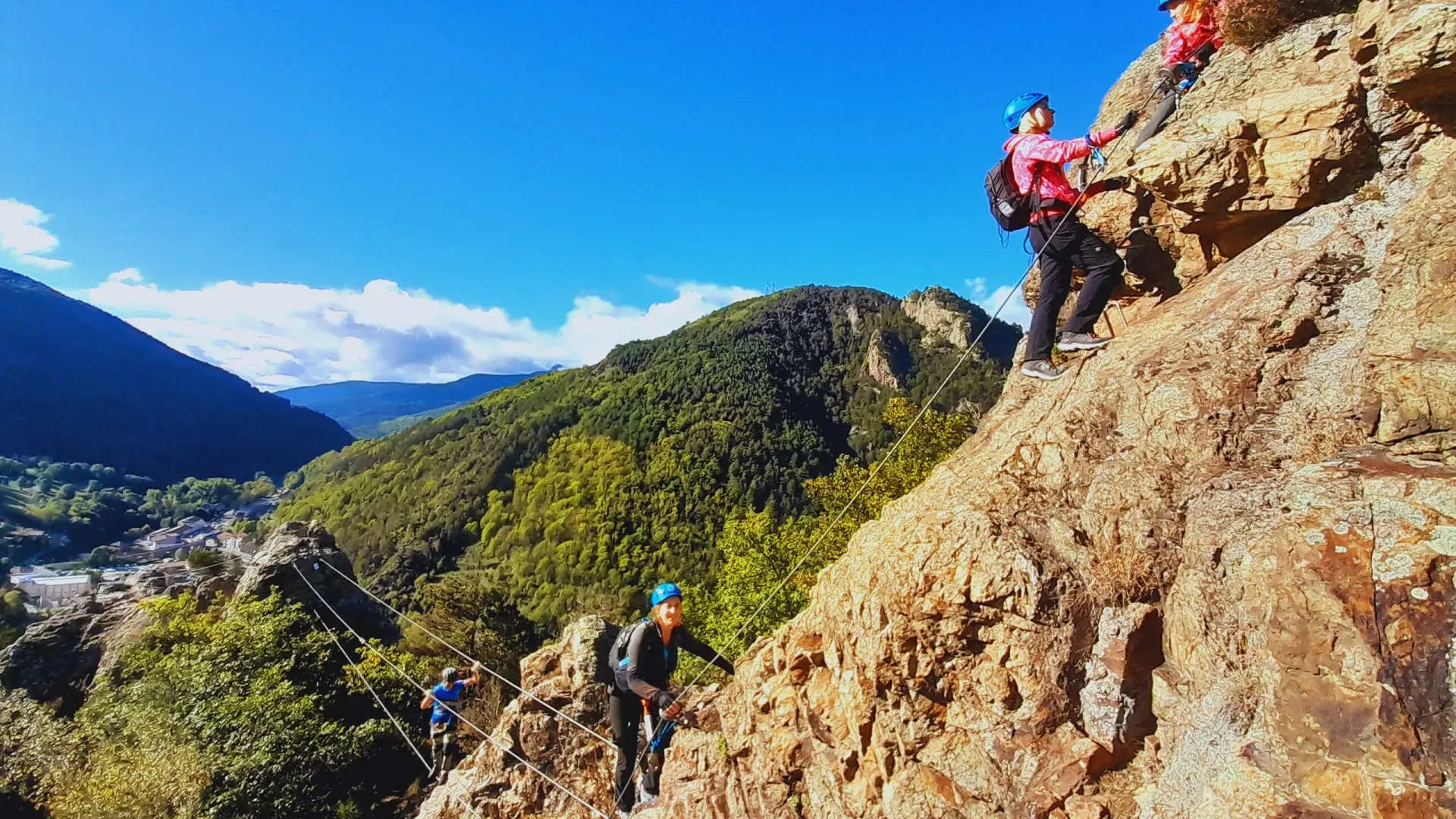 Un grupo de personas está escalando una montaña rocosa.