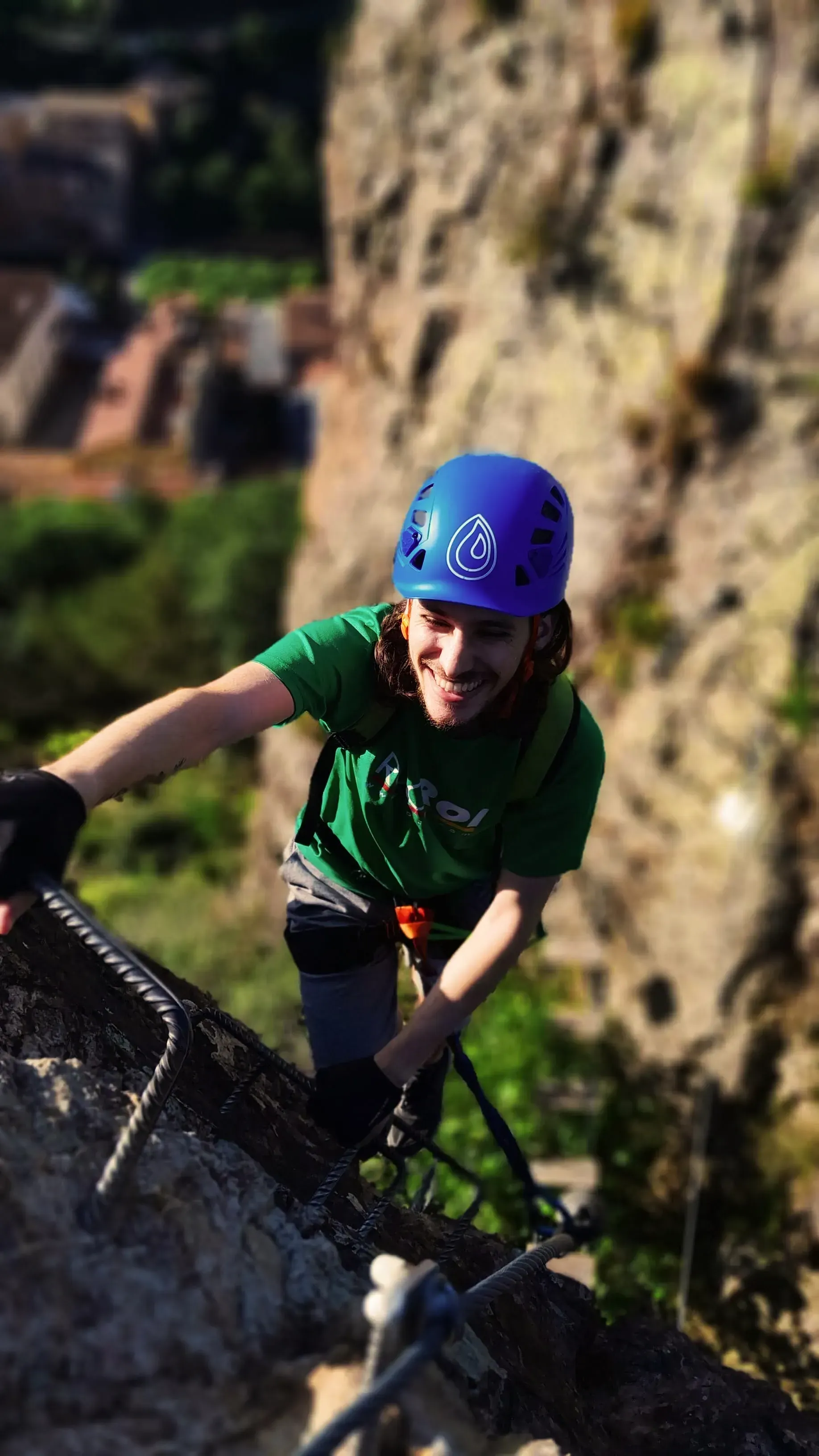 Una persona que lleva un casco azul está escalando una pared de roca.