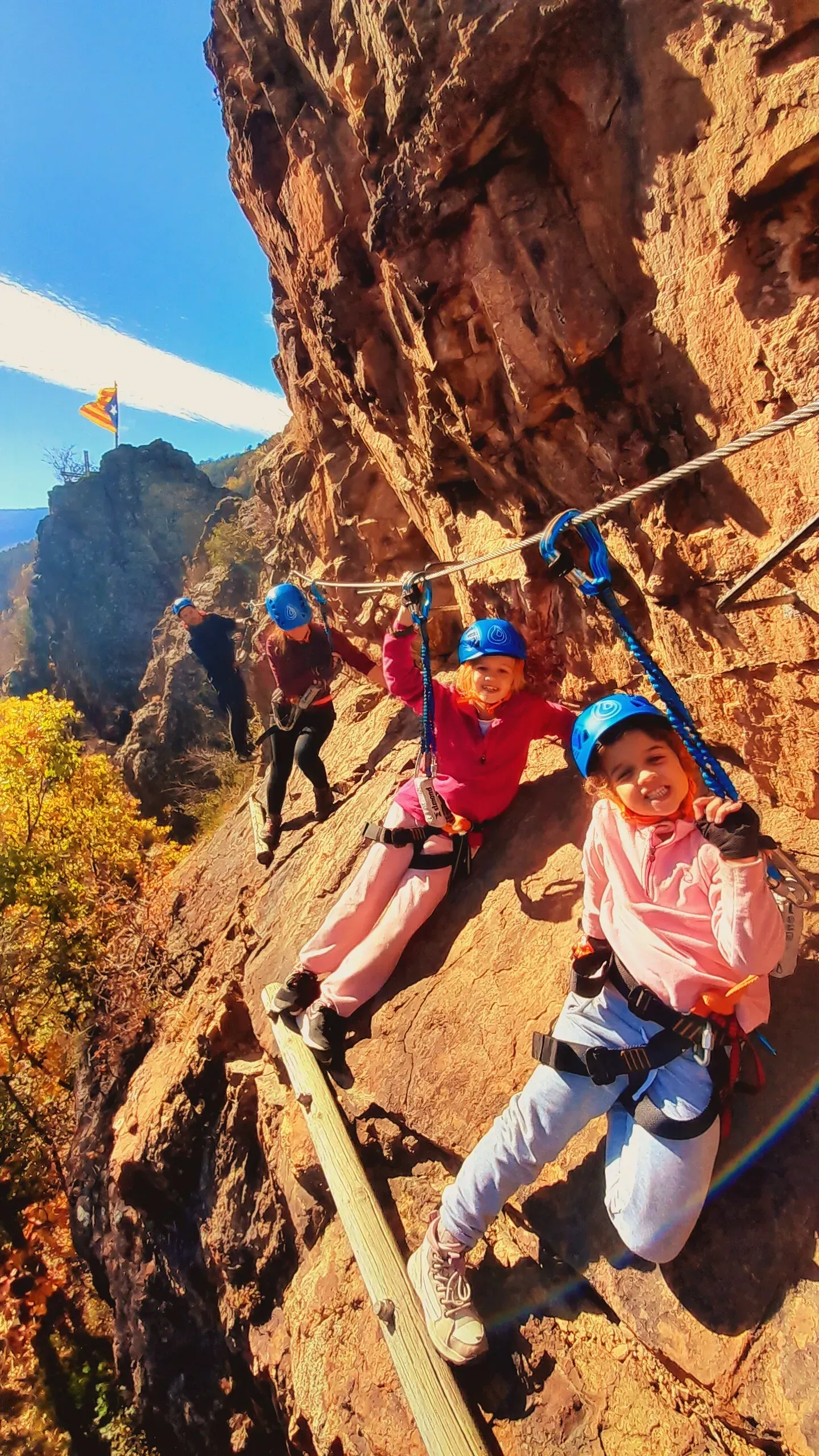 Un grupo de personas está sentado en lo alto de un acantilado rocoso.