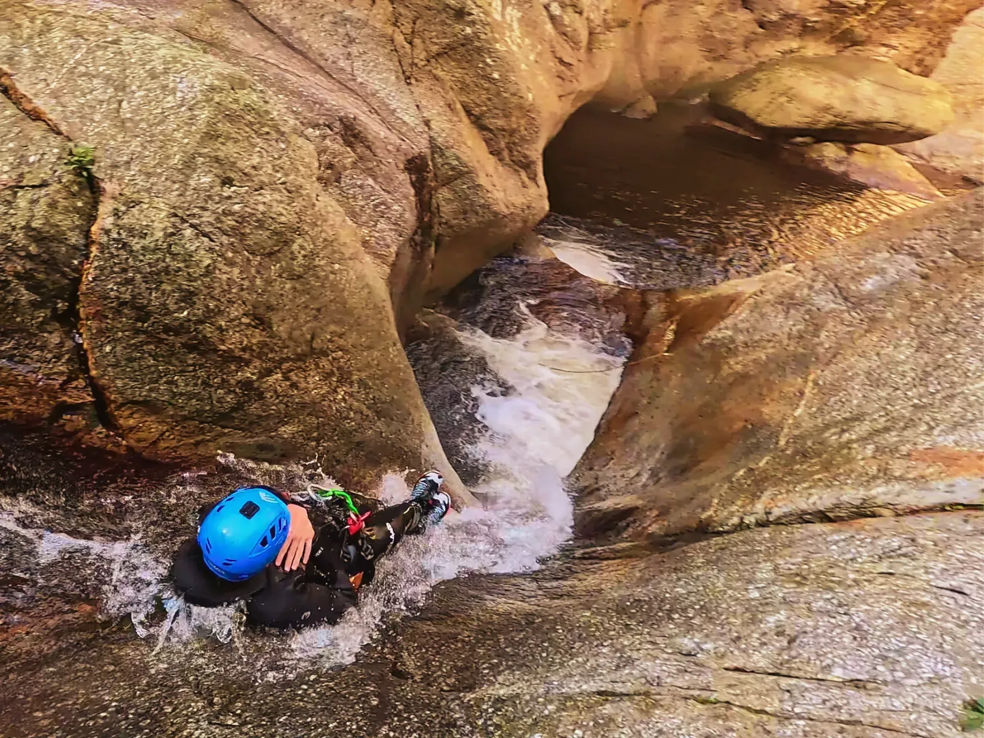 Una persona con un casco azul está nadando en un río.