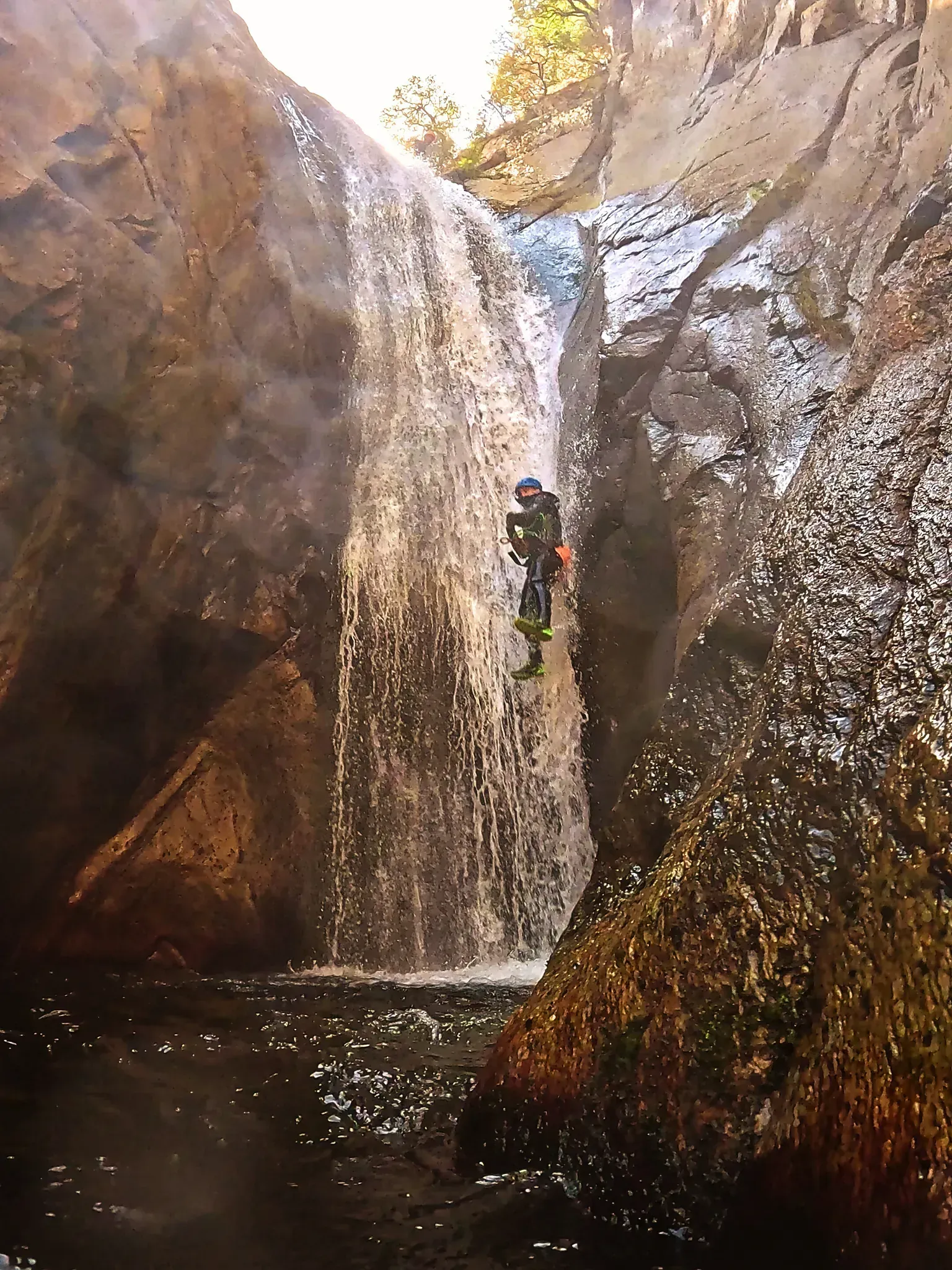 Un hombre está parado en medio de una cascada.