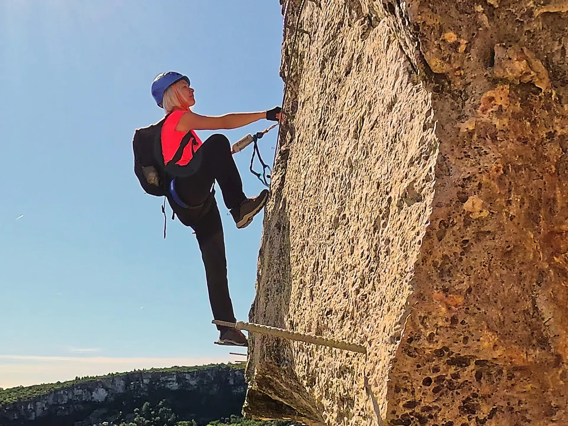 Un hombre está trepando por la ladera de una pared de roca.