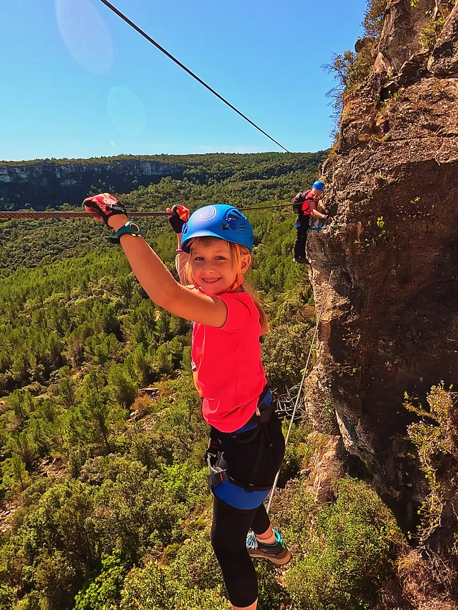 Una niña está colgada de una cuerda en un acantilado.