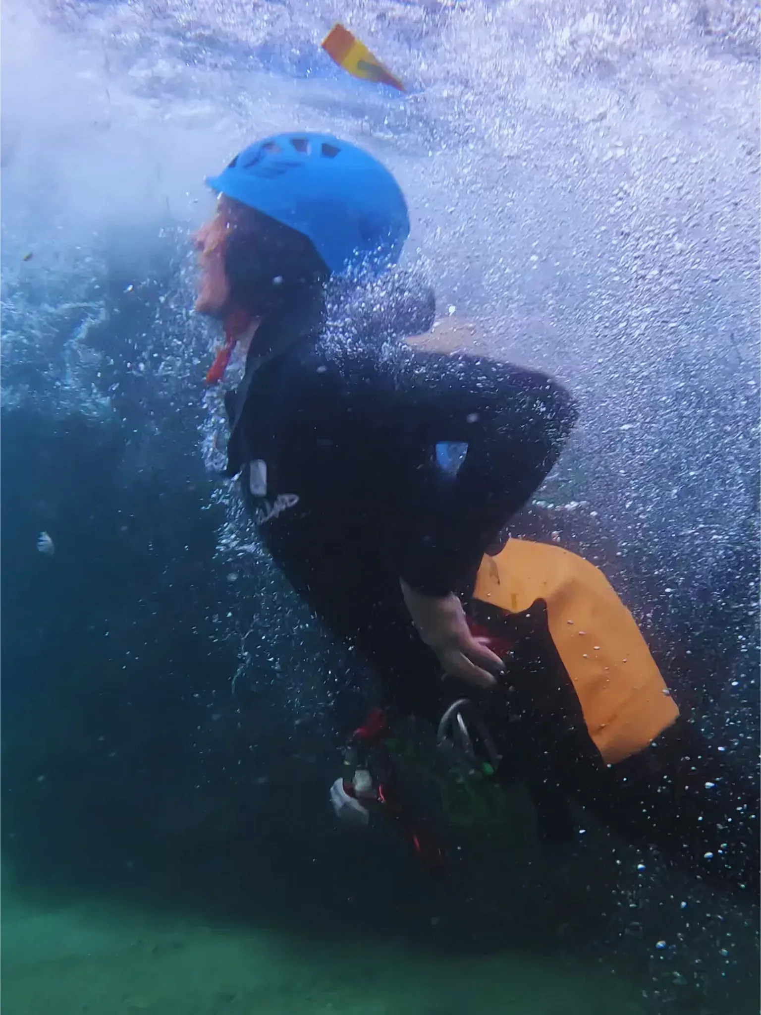 Una persona que lleva un casco azul está nadando en el agua.