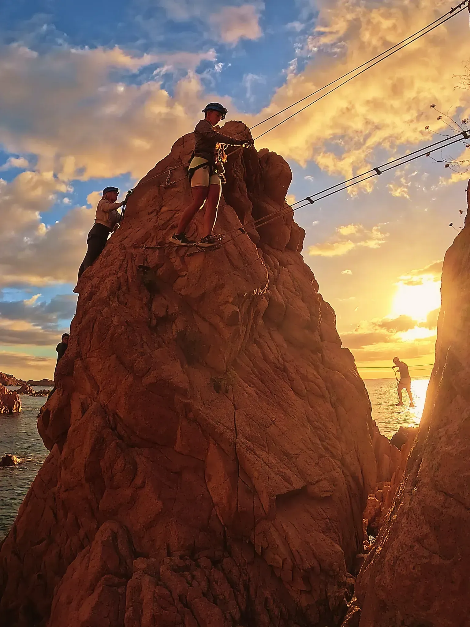 Un par de personas están paradas en la cima de una gran roca.