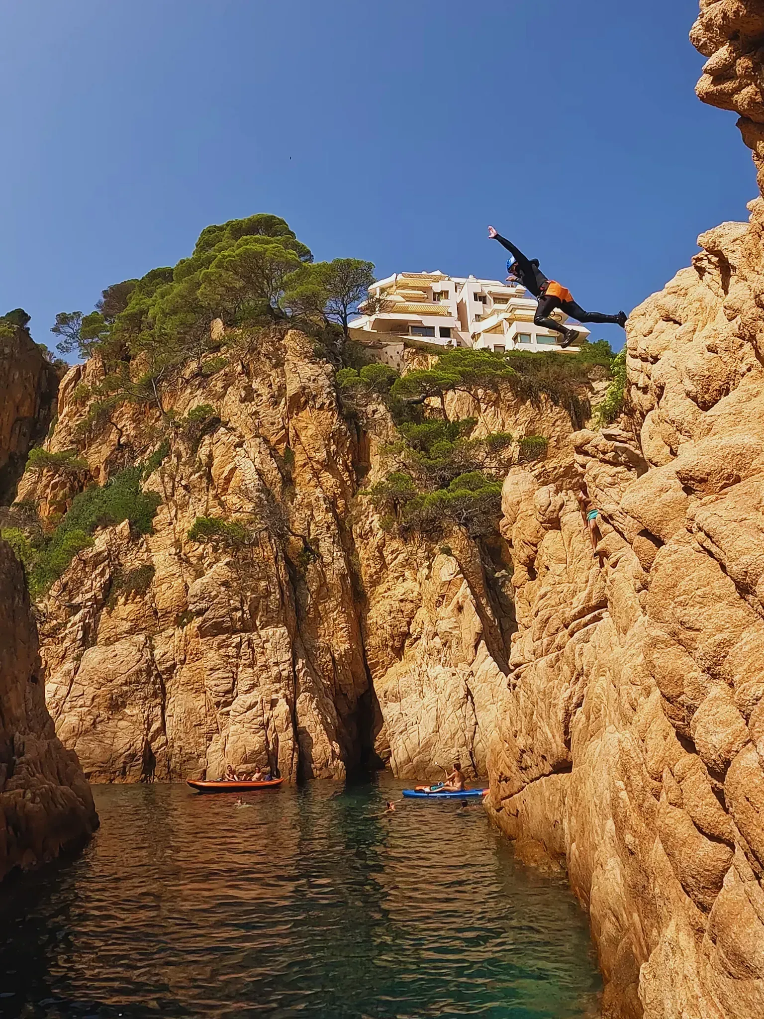 Una persona está saltando desde un acantilado al agua.
