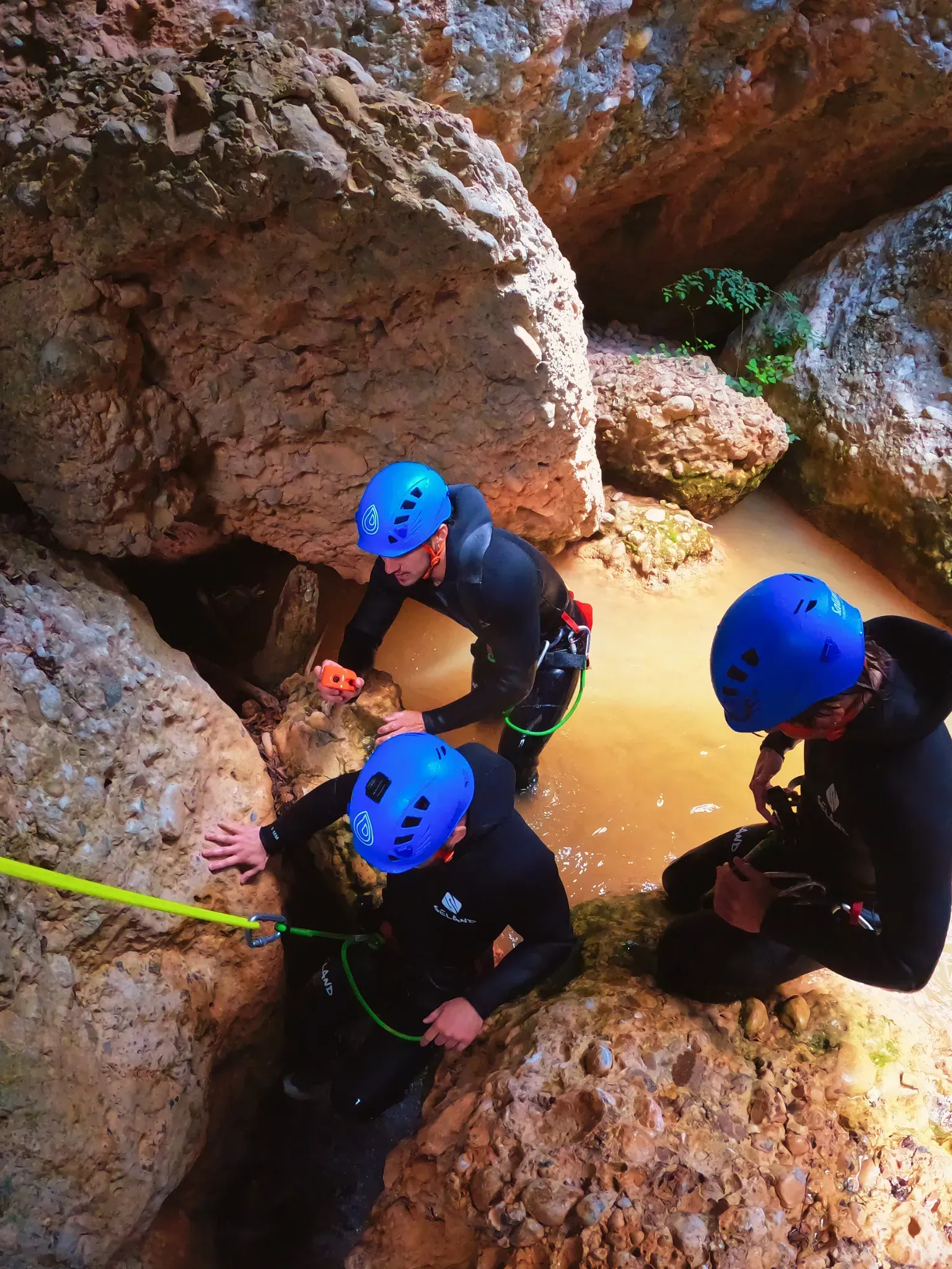 Un grupo de personas que llevan cascos azules están de pie en una cueva.