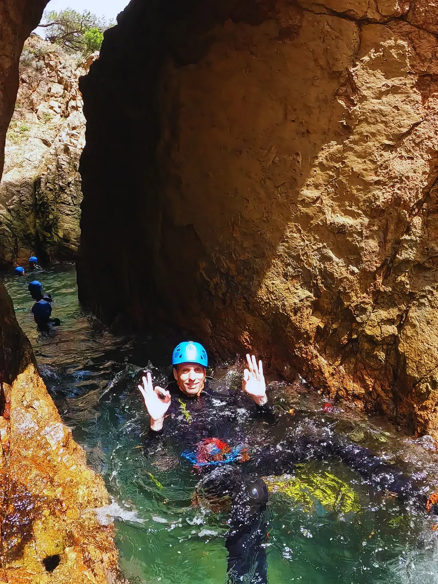 Un hombre con un casco azul está nadando en una cueva.