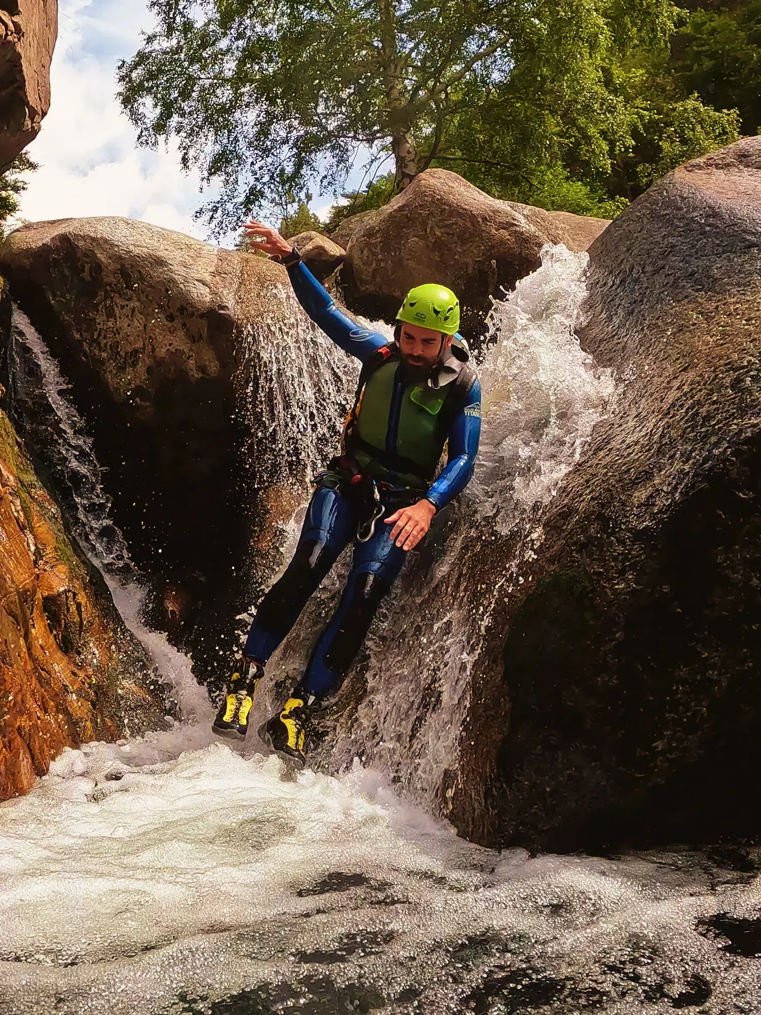 Un hombre con casco está saltando sobre una cascada.