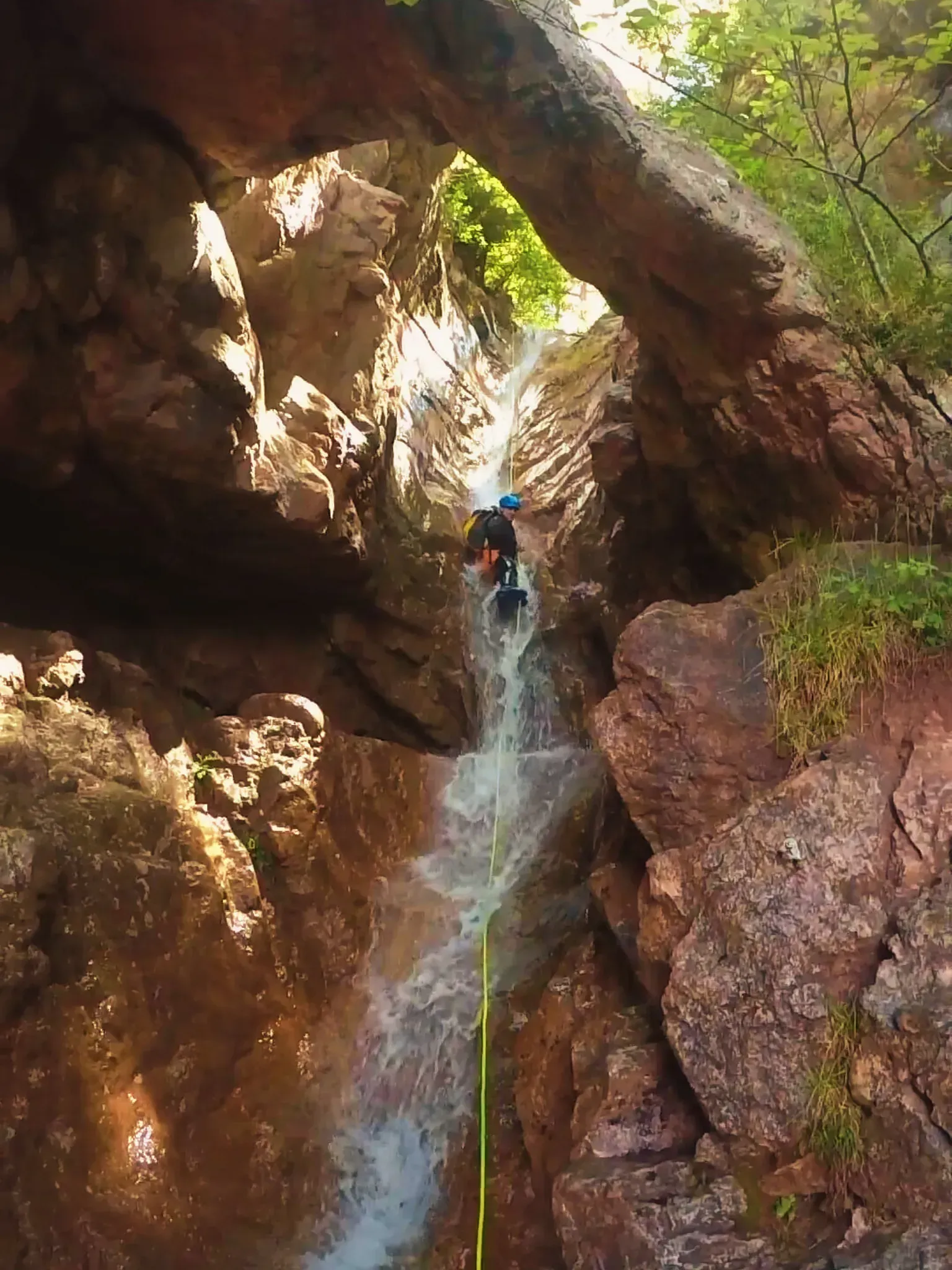 Una persona está subiendo una cascada en un cañón.