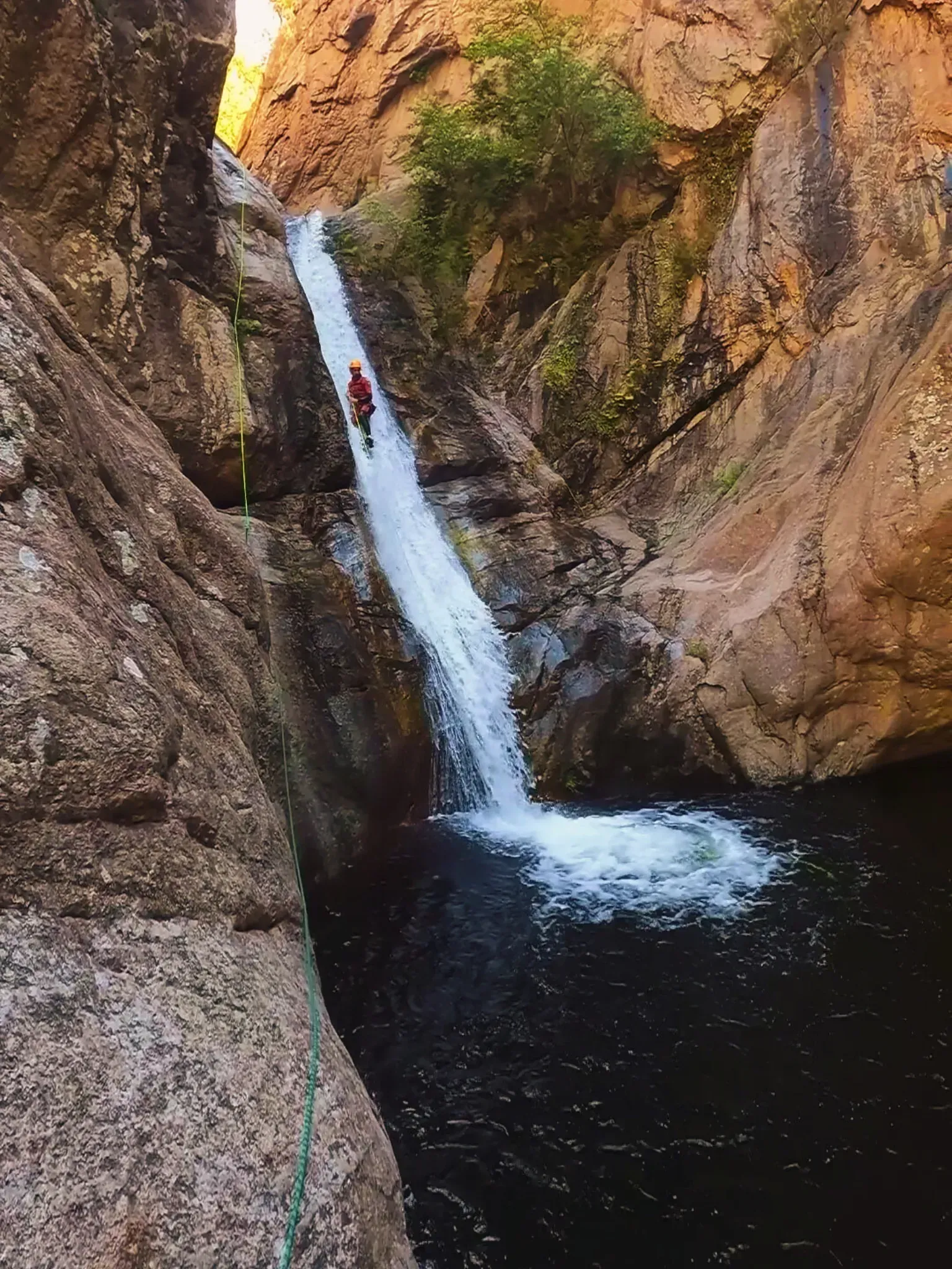 Una persona está subiendo una cascada en un cañón.