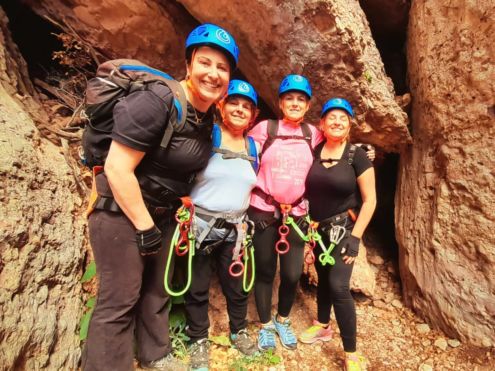 Un grupo de mujeres posa para una fotografía frente a una cueva.