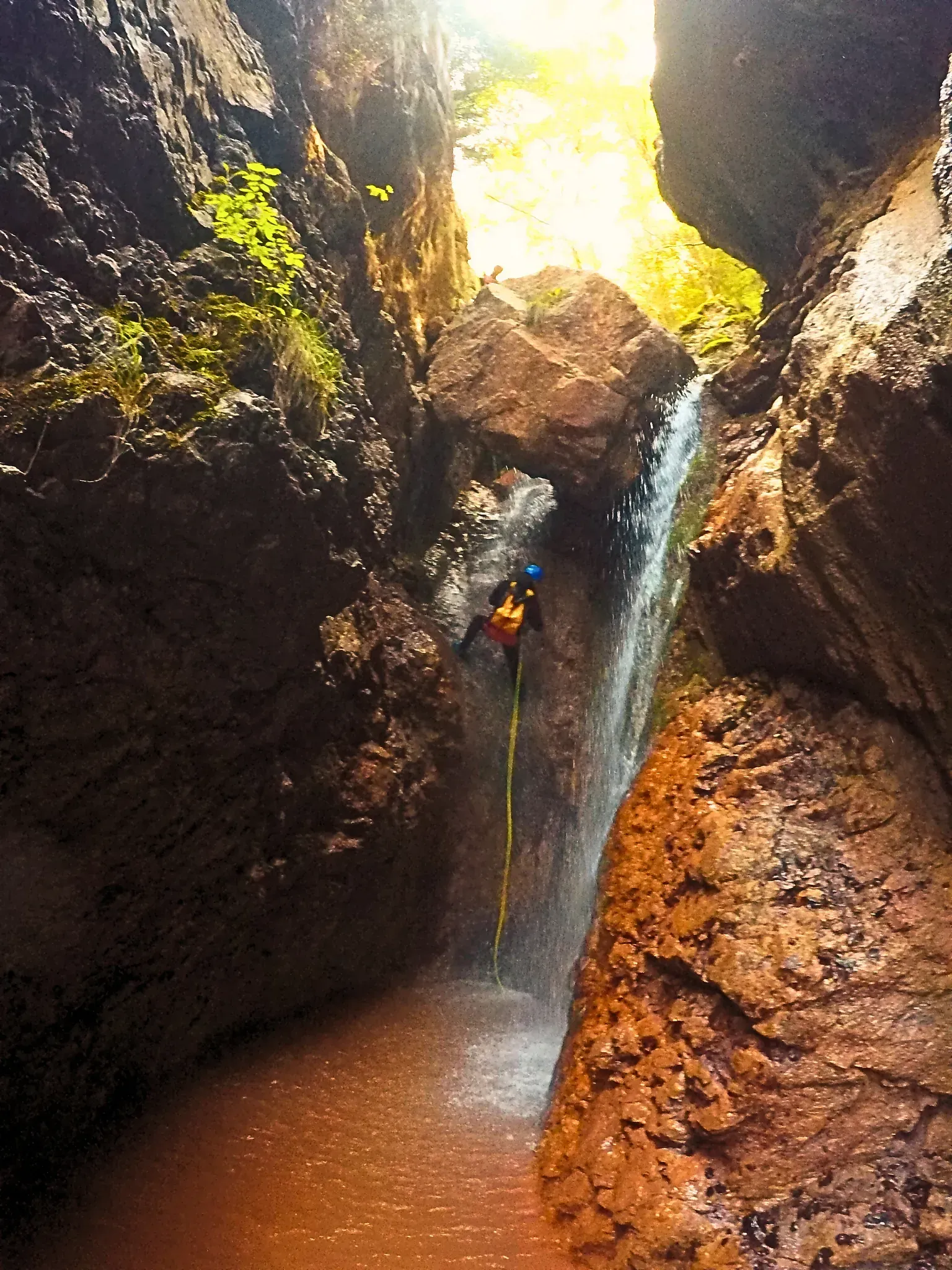 Una persona está subiendo una cascada en un cañón.