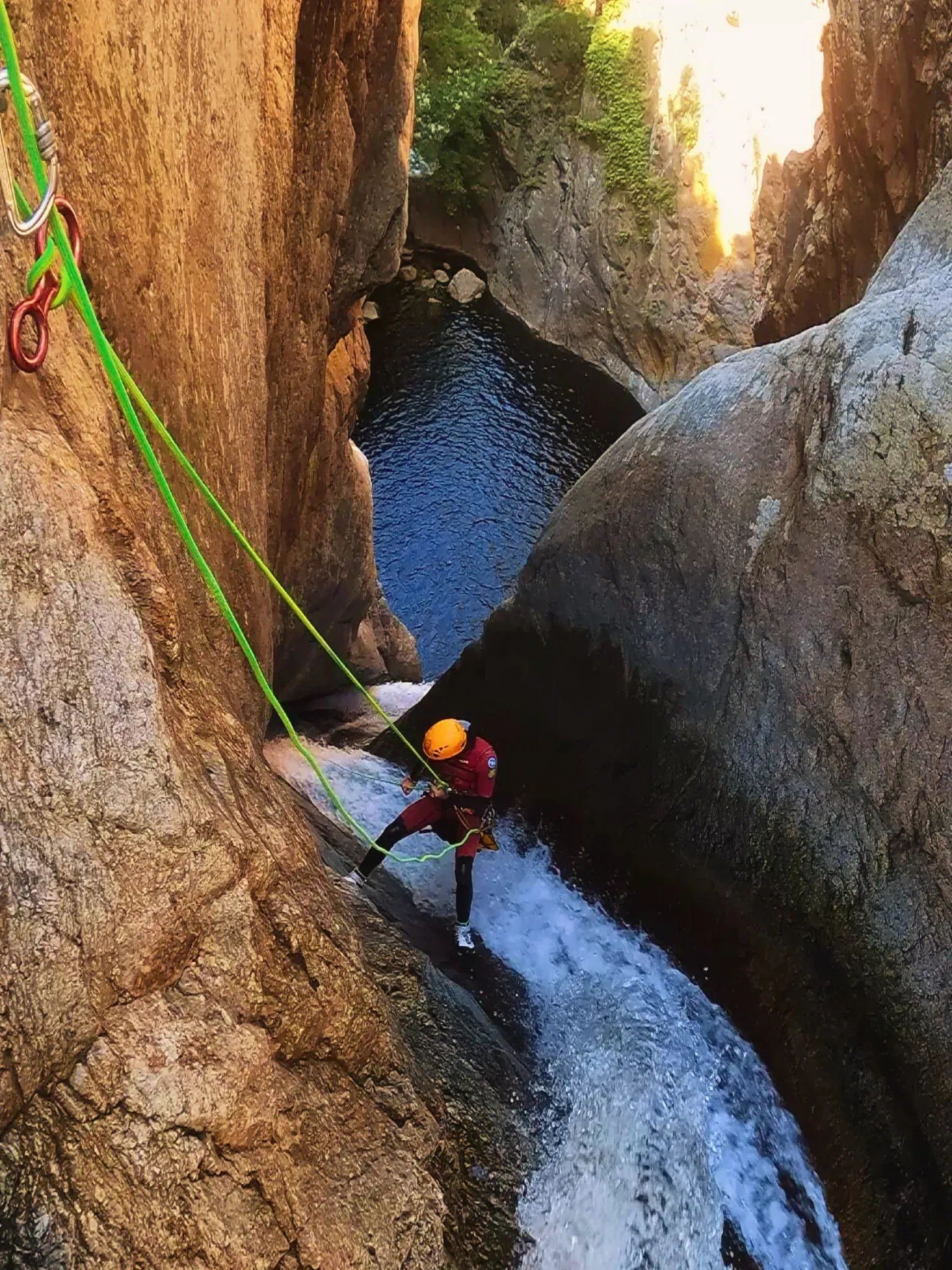 Una persona está bajando por una cascada en un cañón.