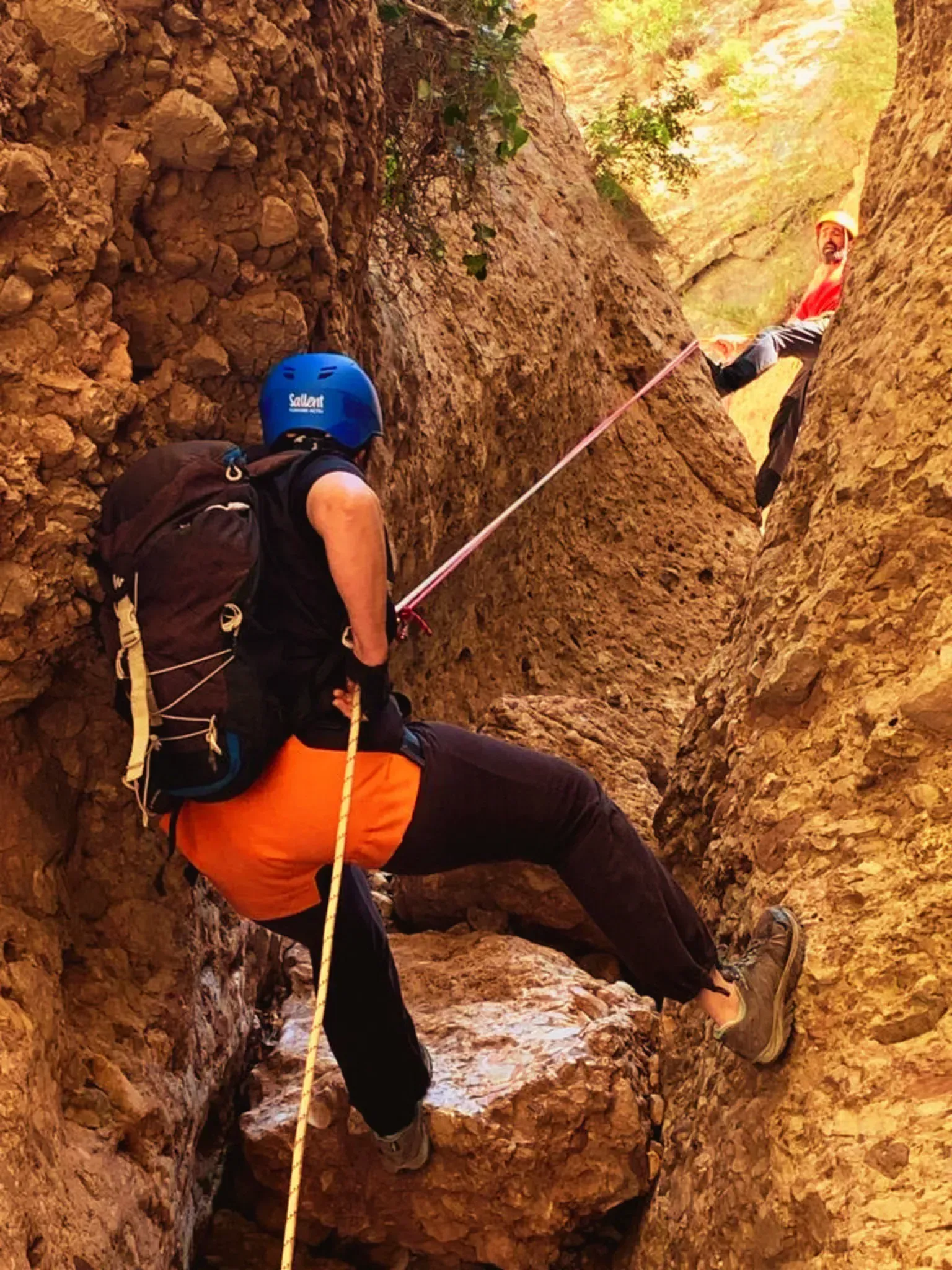 Una persona está escalando una pared de roca con una cuerda.