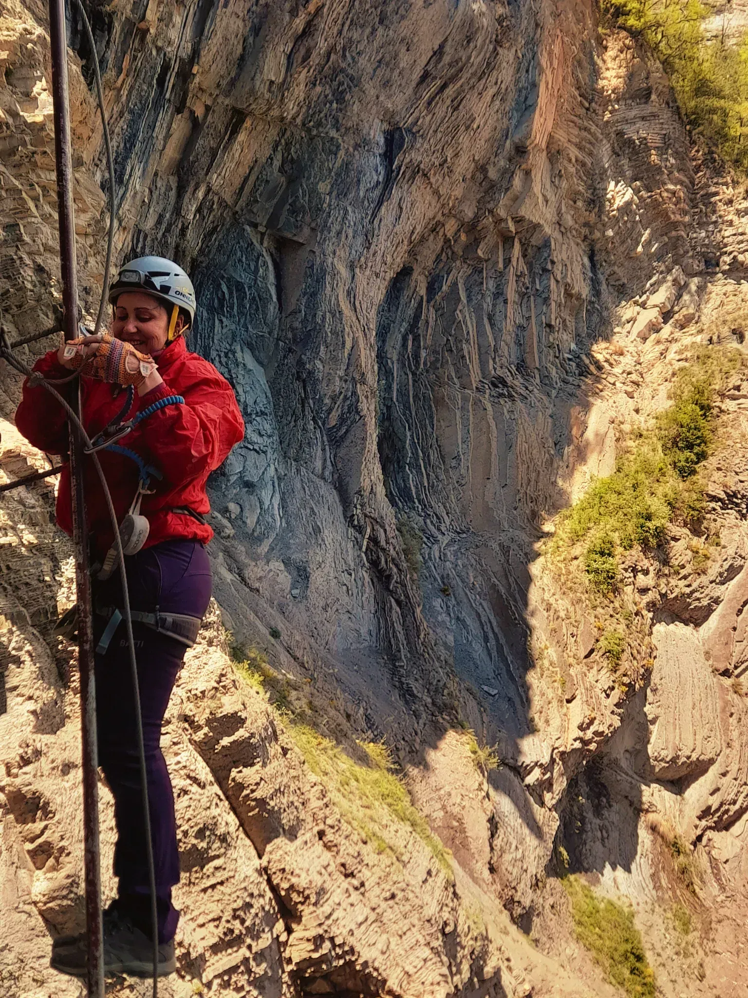 Una persona que lleva un casco está escalando una pared de roca.
