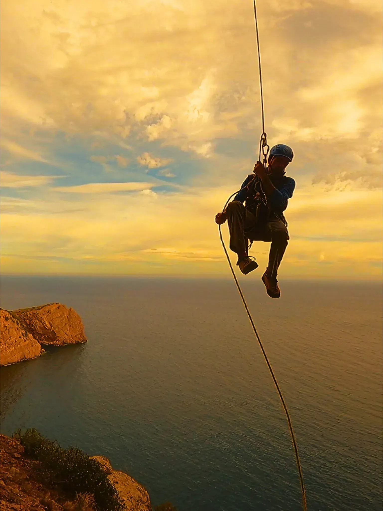 Una persona está colgando de una cuerda sobre el océano.