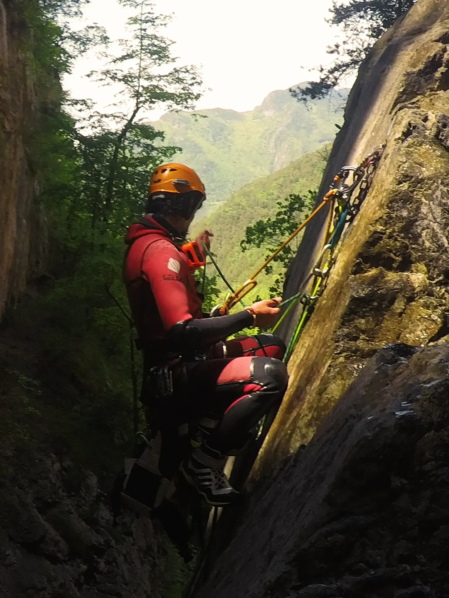 Un hombre que lleva un casco está escalando una pared de roca.