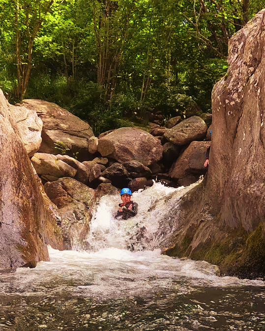 Un hombre con casco está parado frente a una cascada.