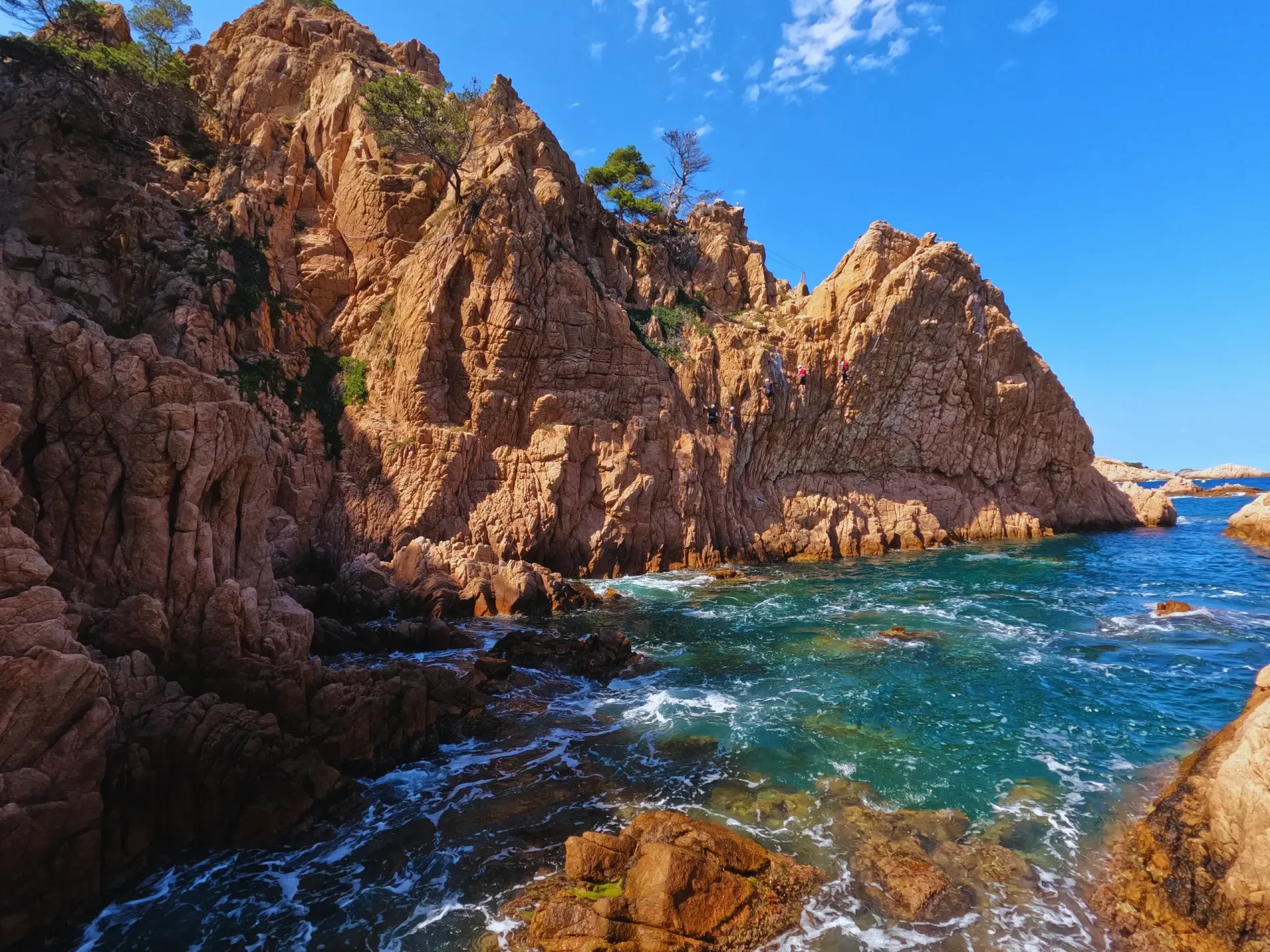 Un acantilado con vistas a un cuerpo de agua con olas rompiendo contra las rocas.