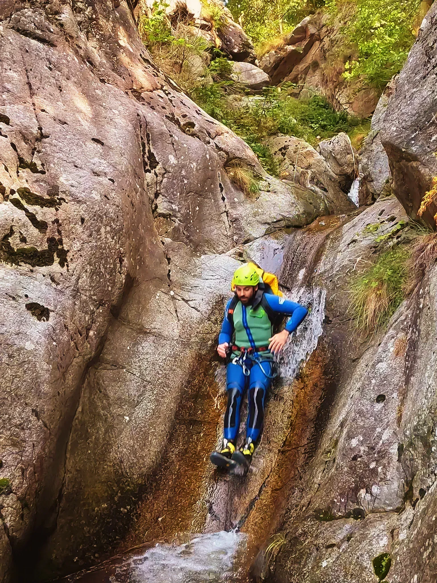 Un hombre está sentado en una roca en un cañón.