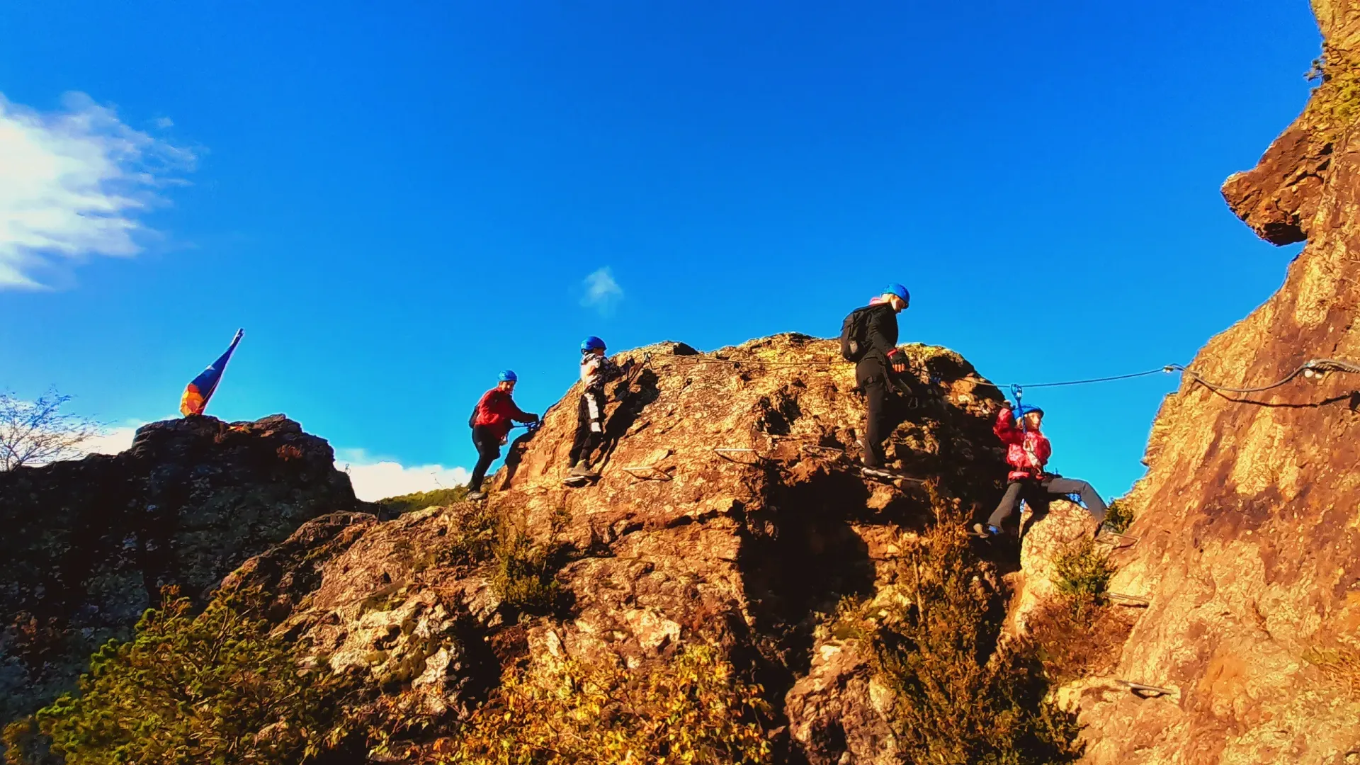 Un grupo de personas está de pie en la cima de una colina rocosa.