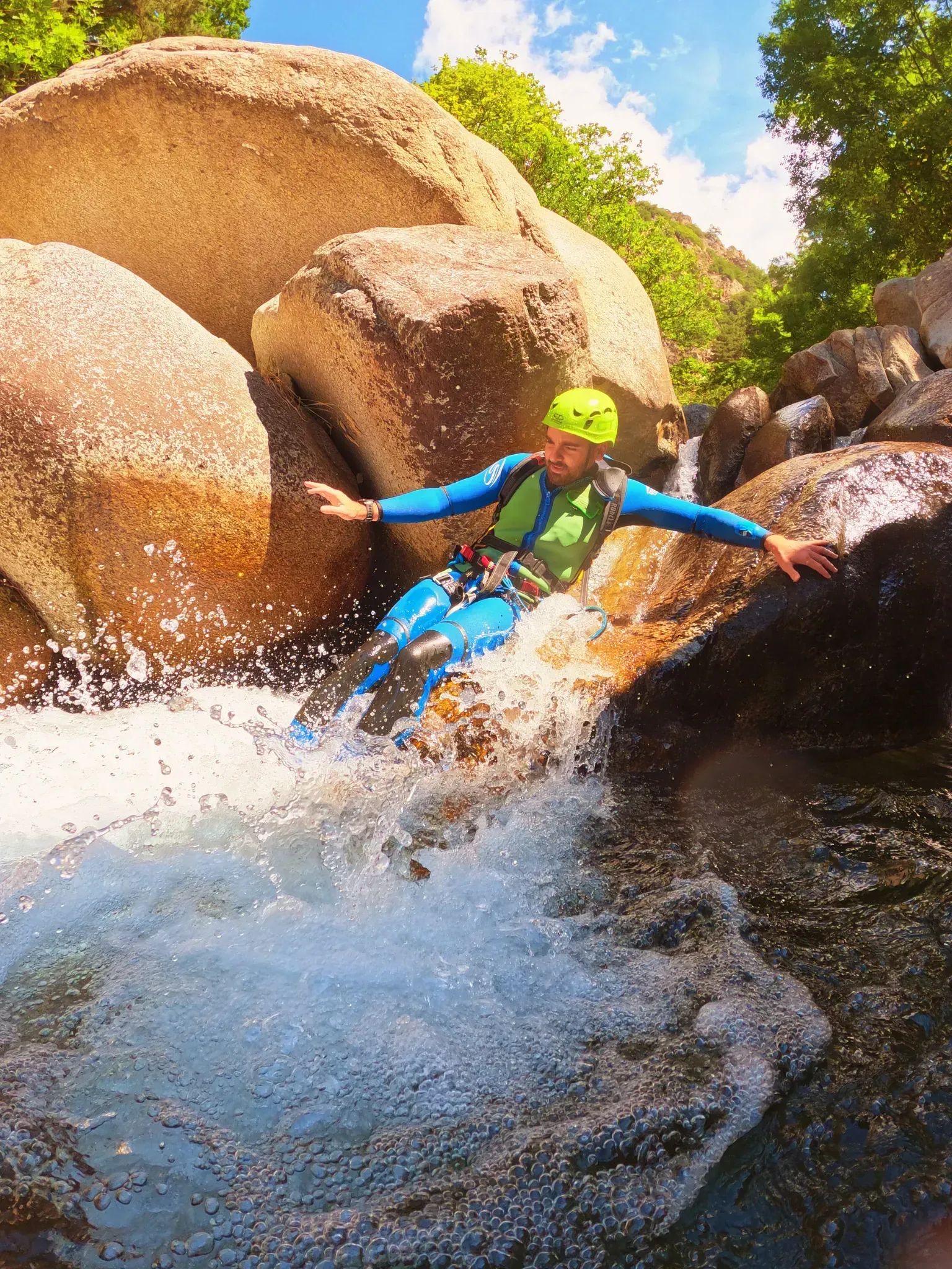 Un hombre está descendiendo por una cascada en un cañón.
