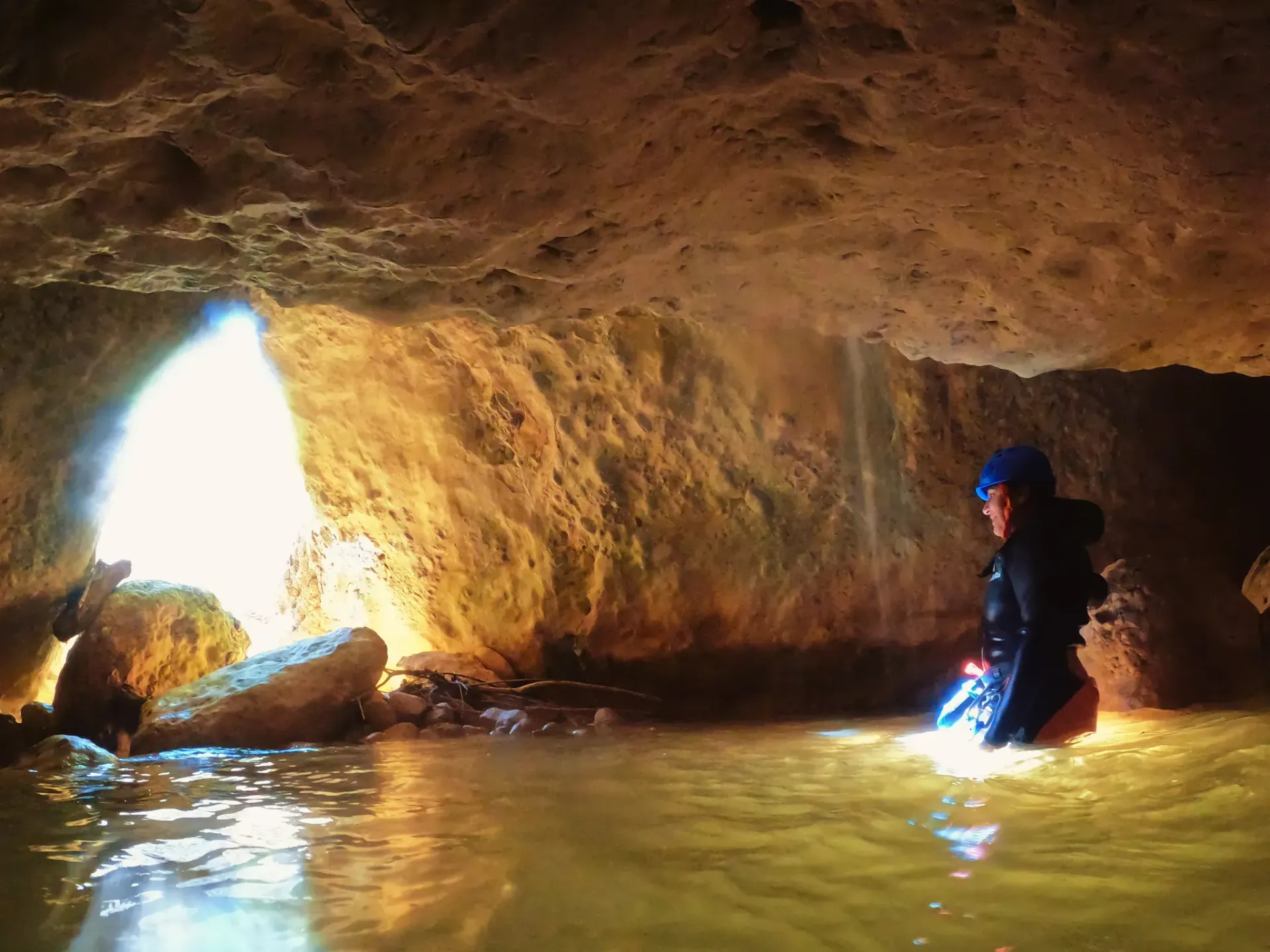 Una persona está parada en una cueva llena de agua.