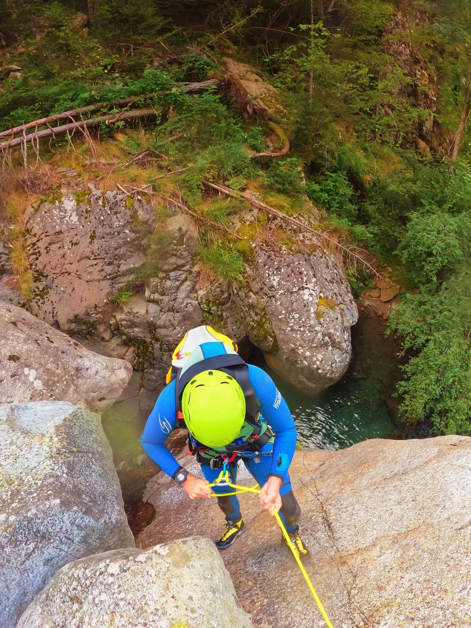 Una persona está subiendo un acantilado rocoso al lado de un río.