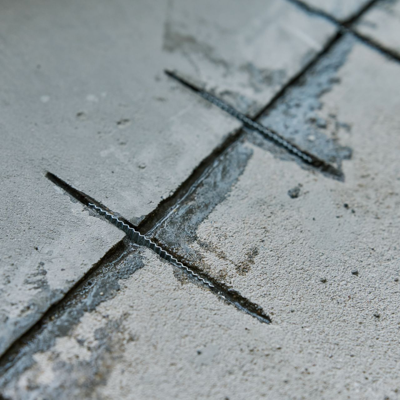 Dalle de béton avec coupes de scie, révélant les armatures.