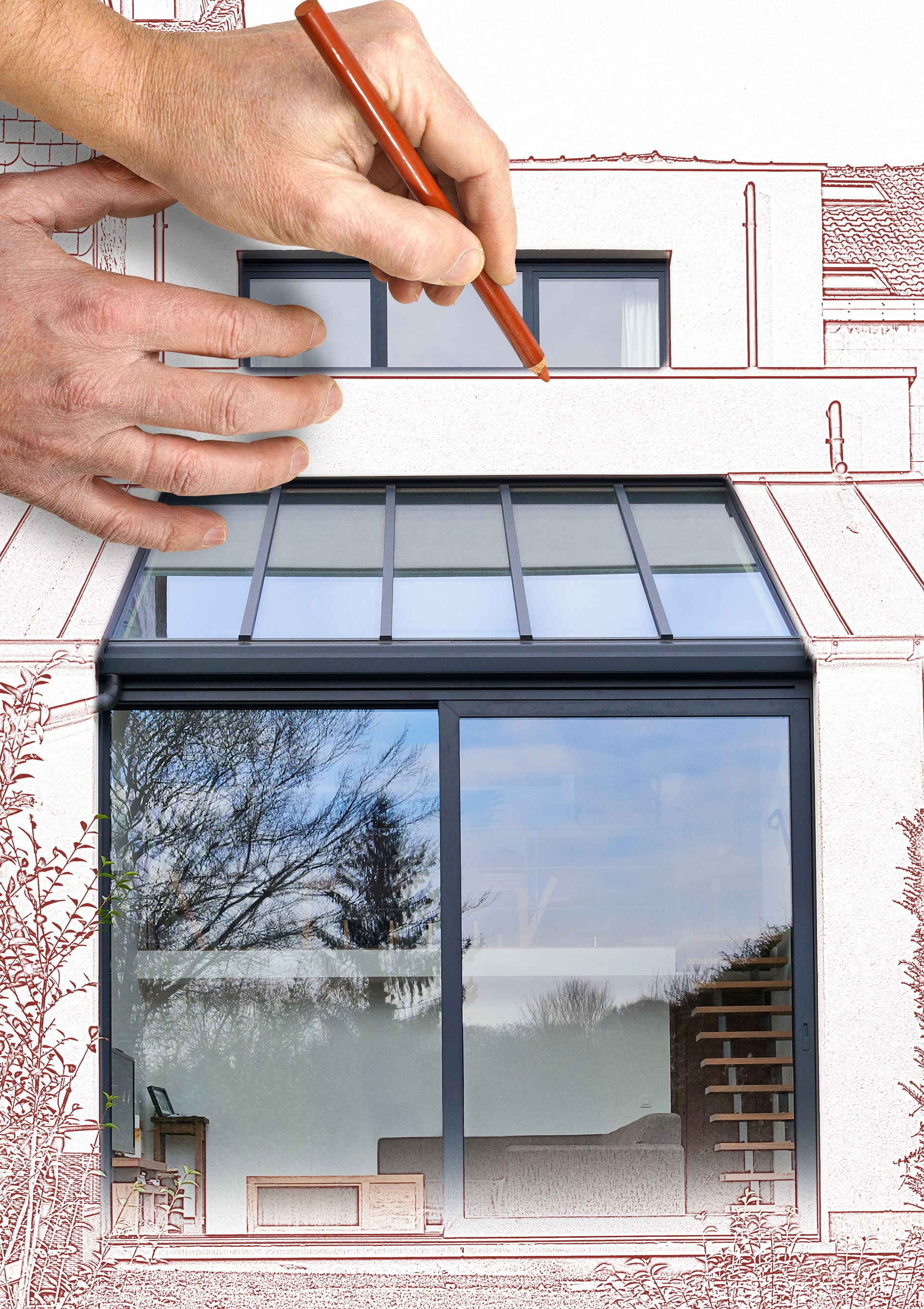 Personne dessinant sur un plan de maison montrant les plans des fenêtres.