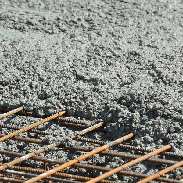 Béton frais coulé sur une grille d'armature en acier pour la construction.