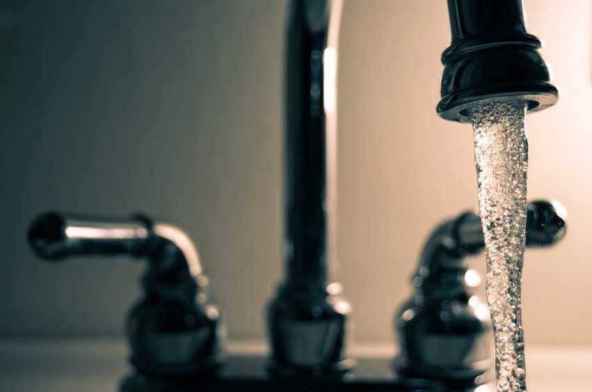 Un primer plano de un grifo del que sale agua.
