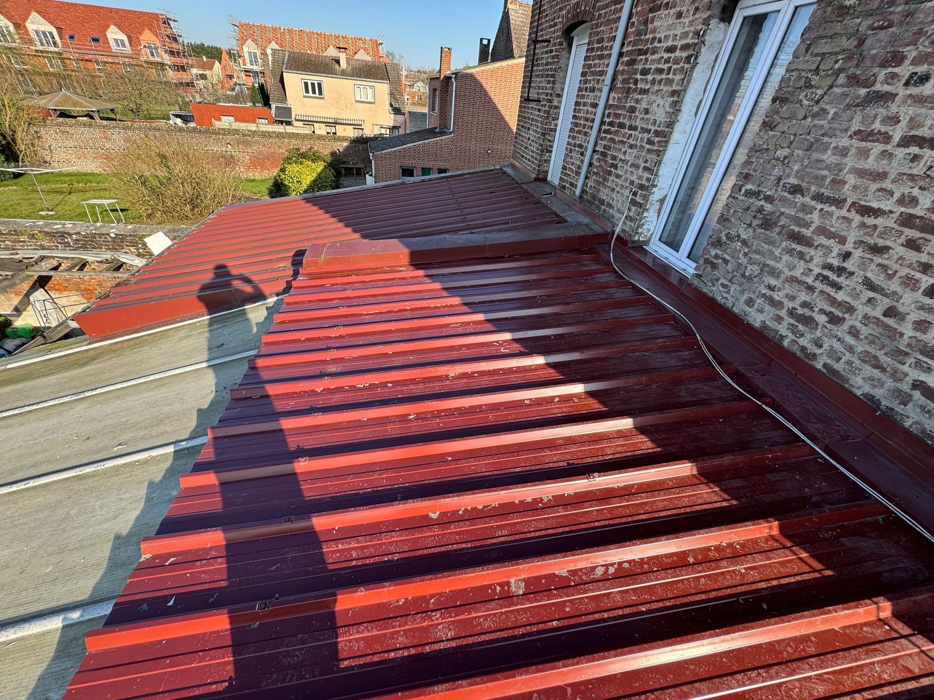 Un homme répare une gouttière avec un marteau