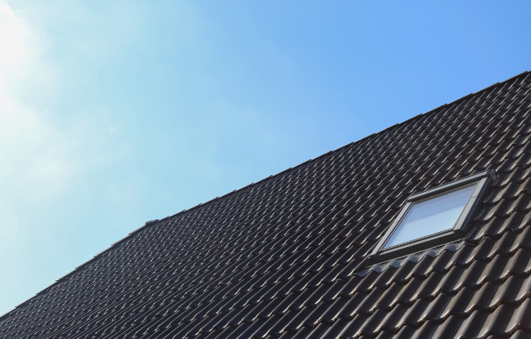 Un toit avec une lucarne et un ciel bleu en arrière-plan