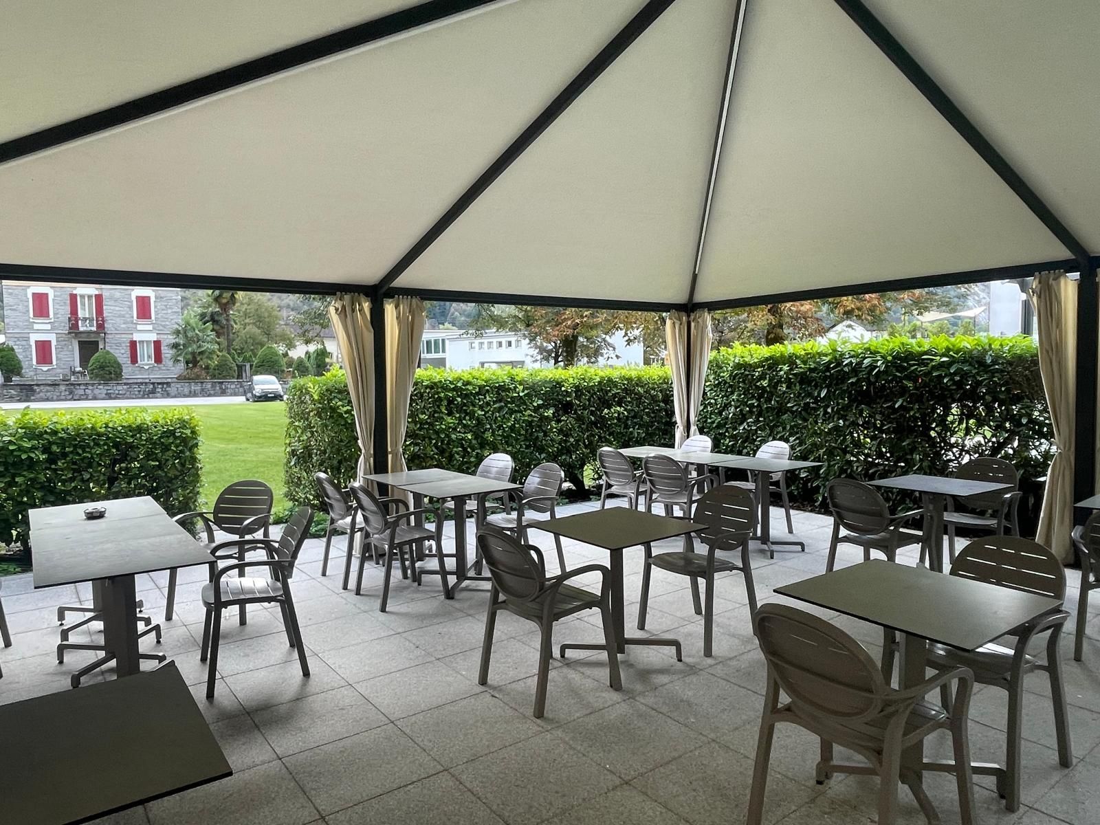 Cornetti su un piatto blu scuro con caffè e fiori bianchi sullo sfondo.
