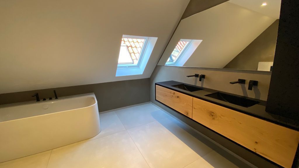 Badewanne unter Dachschräge und großem modernen Waschtisch