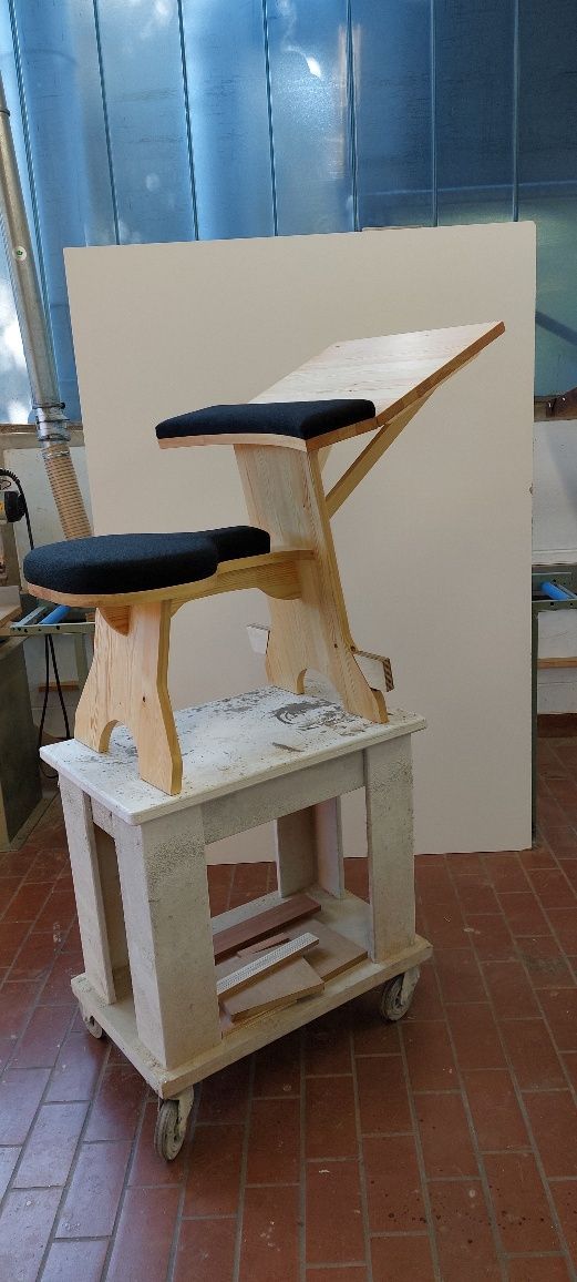 Ein Holztisch mit einem Hocker darauf in einem Raum.