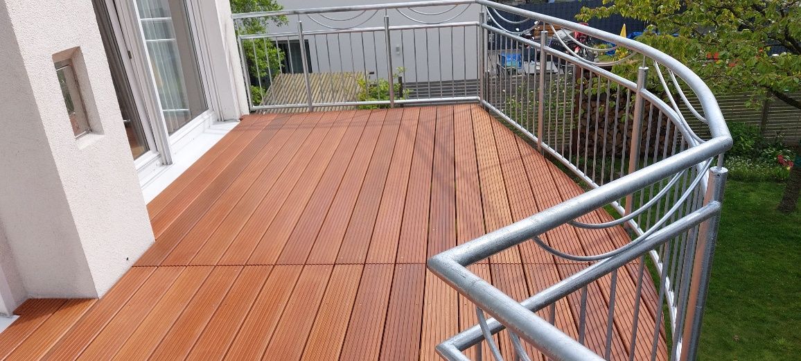 Ein Balkon mit Holzterrasse und Metallgeländer