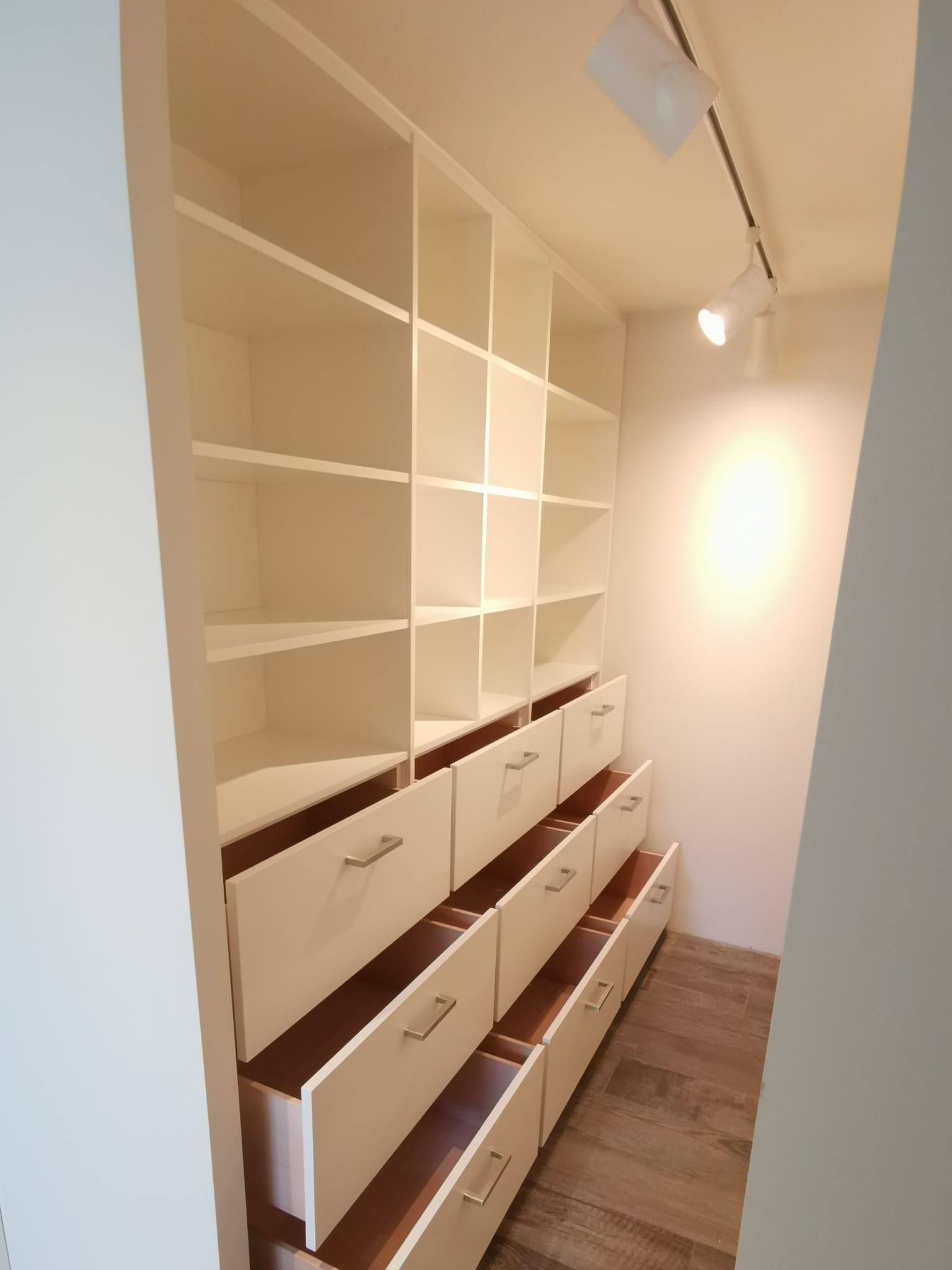 Ein begehbarer Kleiderschrank mit offenen Regalen und Schubladen