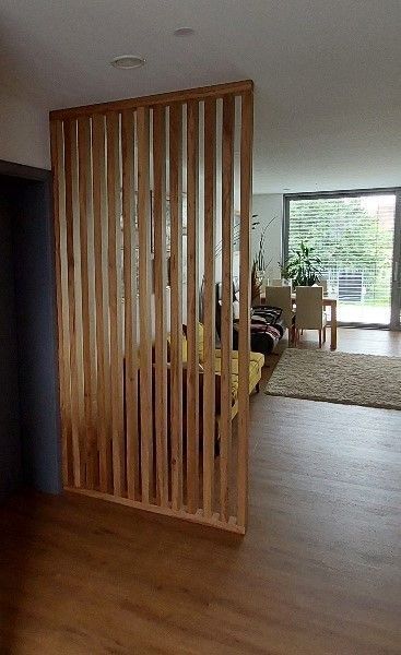 Ein Raumteiler aus Holz steht in der Mitte eines Wohnzimmers.