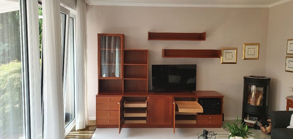 Ein Wohnzimmer mit einem Entertainment-Center aus Holz und einem Flachbildfernseher.