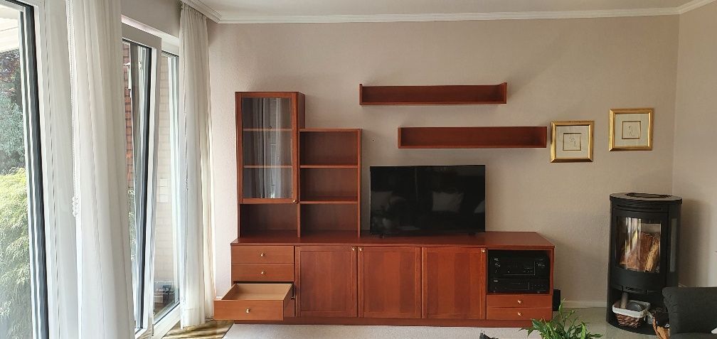 Ein Wohnzimmer mit einem Entertainment-Center aus Holz und einem Flachbildfernseher.
