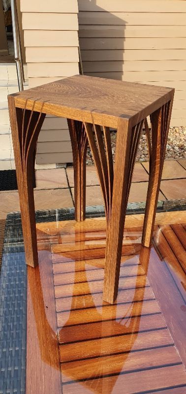 Auf einem Holzdeck steht ein kleiner Holztisch.